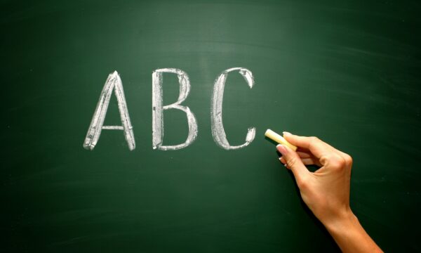 Abc Letters With Hand And Chalk On Blackboard